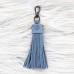 Blue tassel keychain on a textured white surface