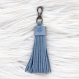 Blue tassel keychain on a textured white surface