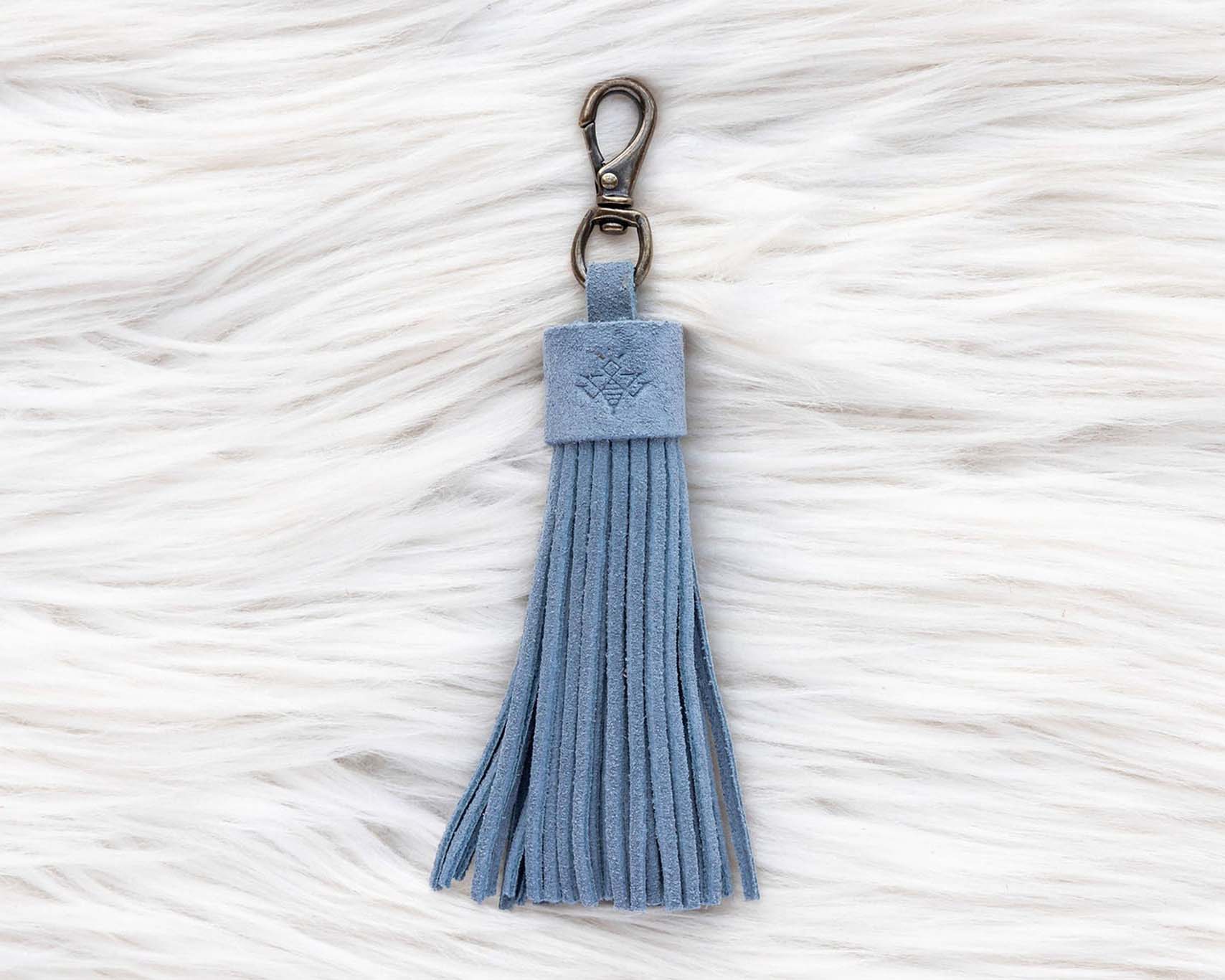 Blue tassel keychain on a textured white surface