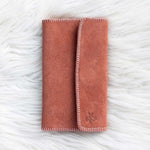Folded pink blanket on a textured white surface