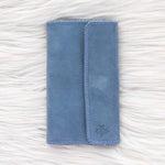 Blue fabric pouch on a textured white surface