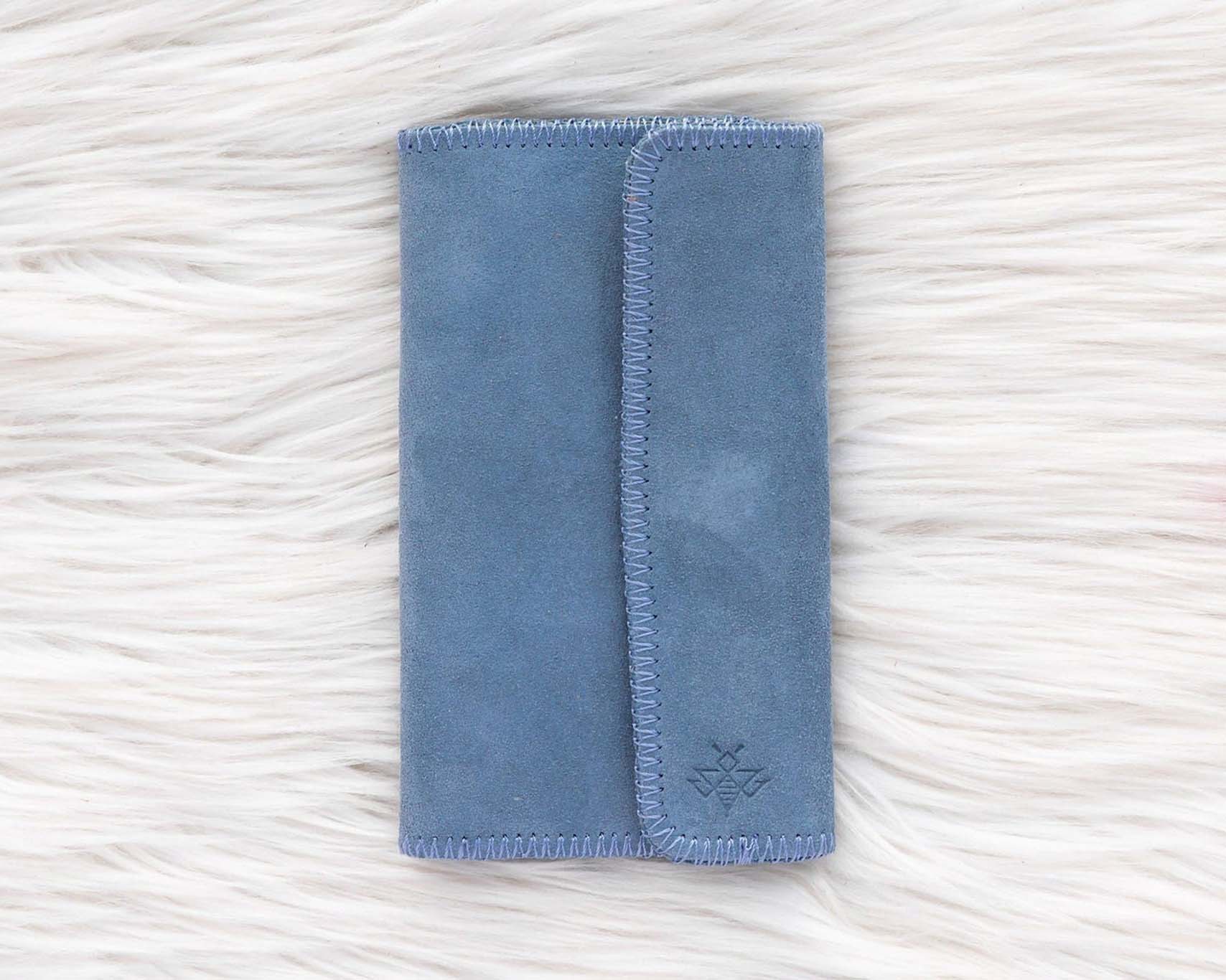 Blue fabric pouch on a textured white surface