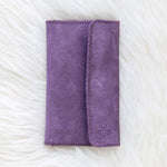 Purple wallet on a textured white surface