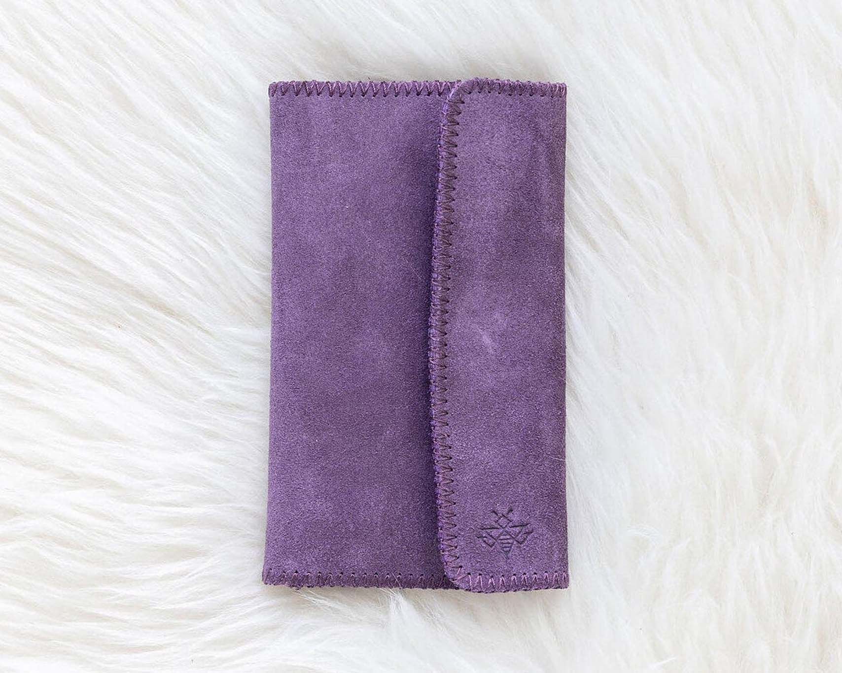 Purple wallet on a textured white surface